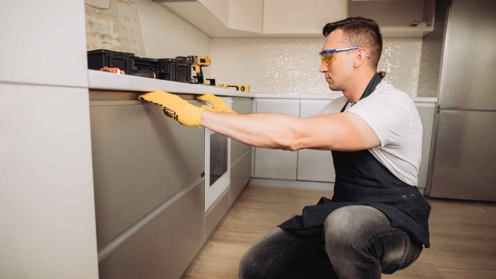 Expert carpenter performing wood kitchen installation for a modern home